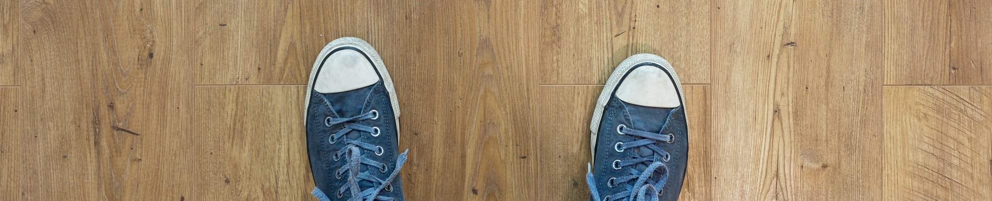 Person in sneakers standing on hardwood planks